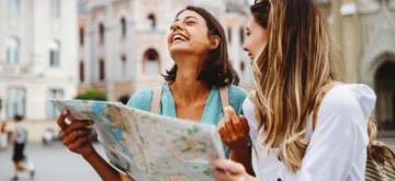 Summer Smile Survival Guide - A pair of friends traveling during the summer. Laughing looking at a map