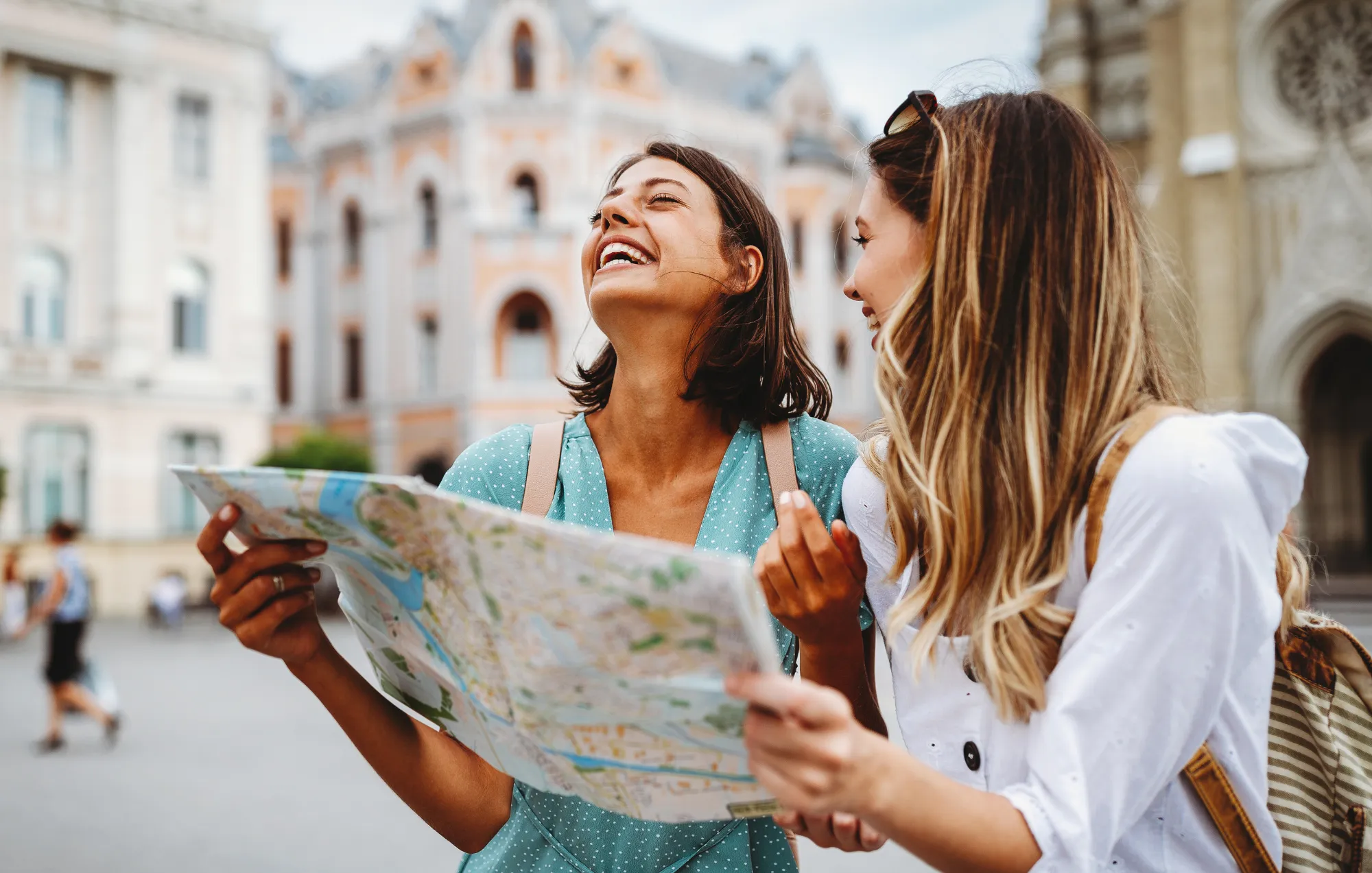 Summer Smile Survival Guide - A pair of friends traveling during the summer. Laughing looking at a map