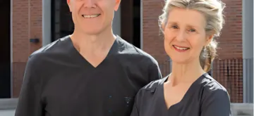 A professional photo of Dr Ray McCarthy and Dr Susan Kiely, previously of Fitzwilliam Dental wearing scrubs standing outside the Northumberland practice.