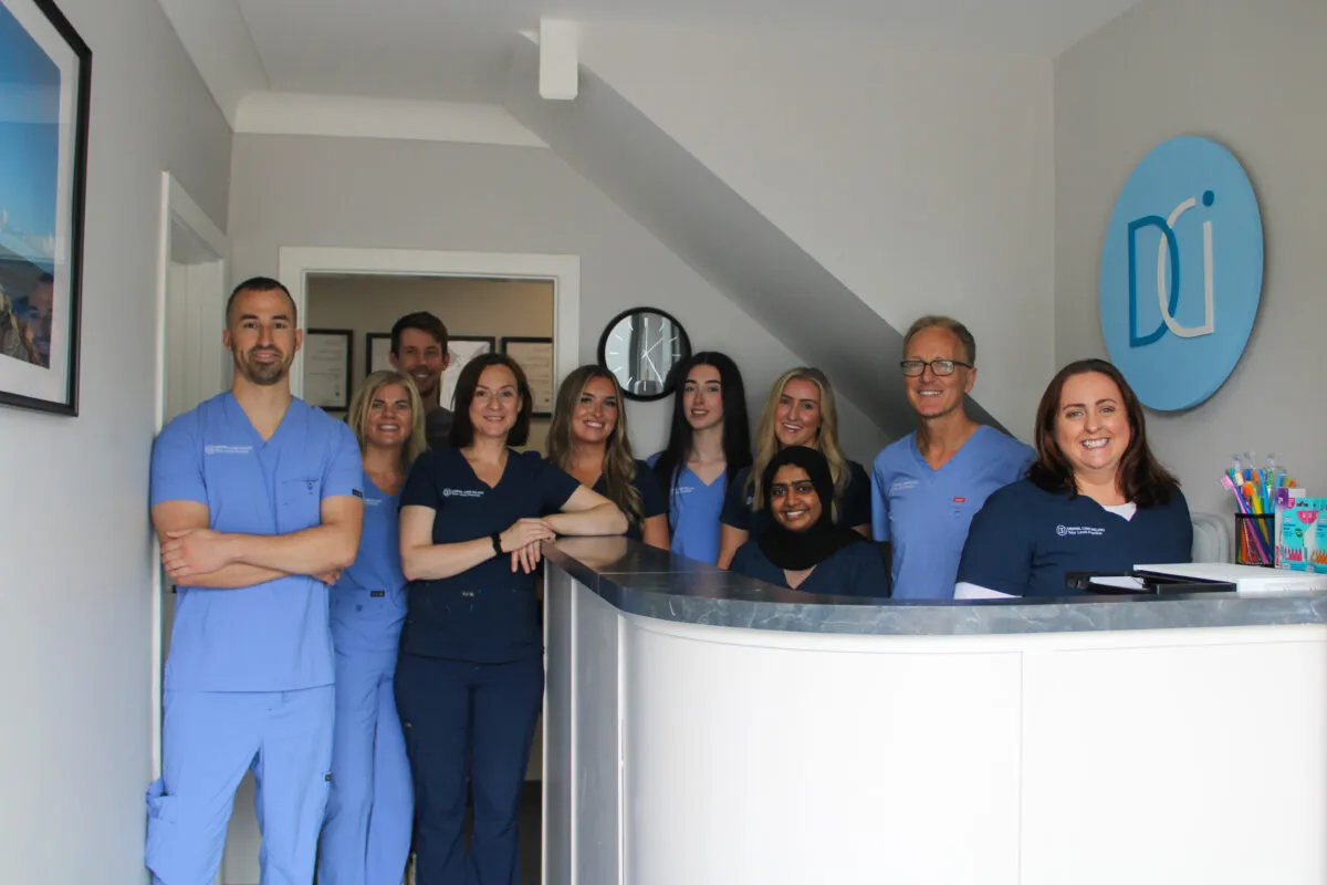 A group photo of the Dental Care Ireland Rathfarnham team at the reception desk.