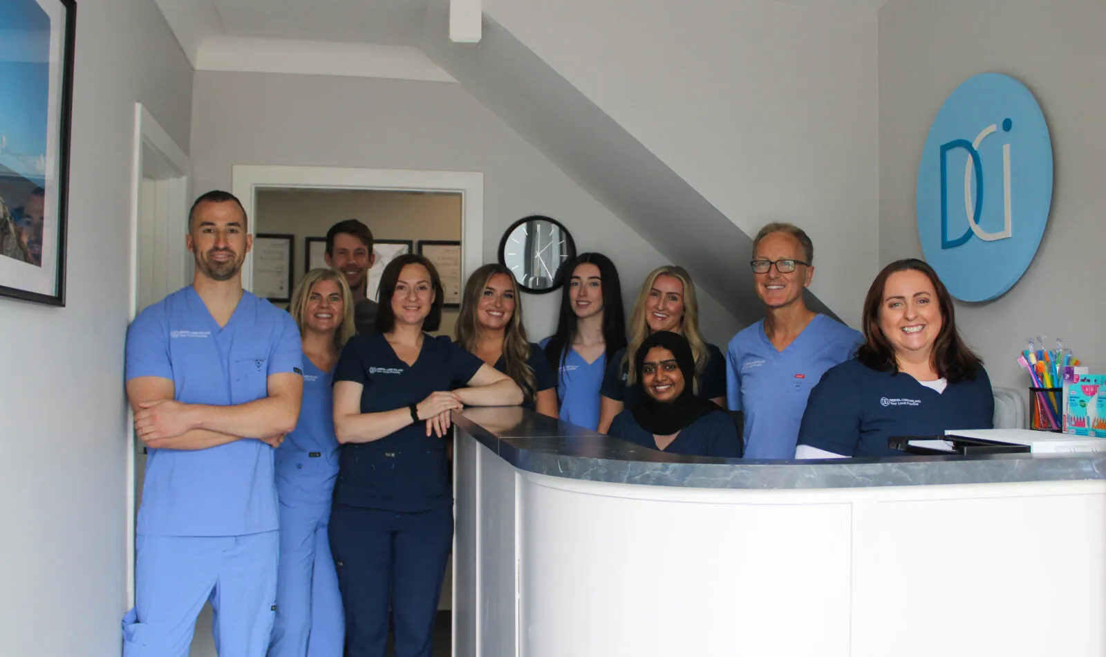 A group photo of the Dental Care Ireland Rathfarnham team at the reception desk.