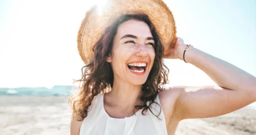 teeth whitening blog titled summer smile - picture has a woman at the beach showing her white teeth