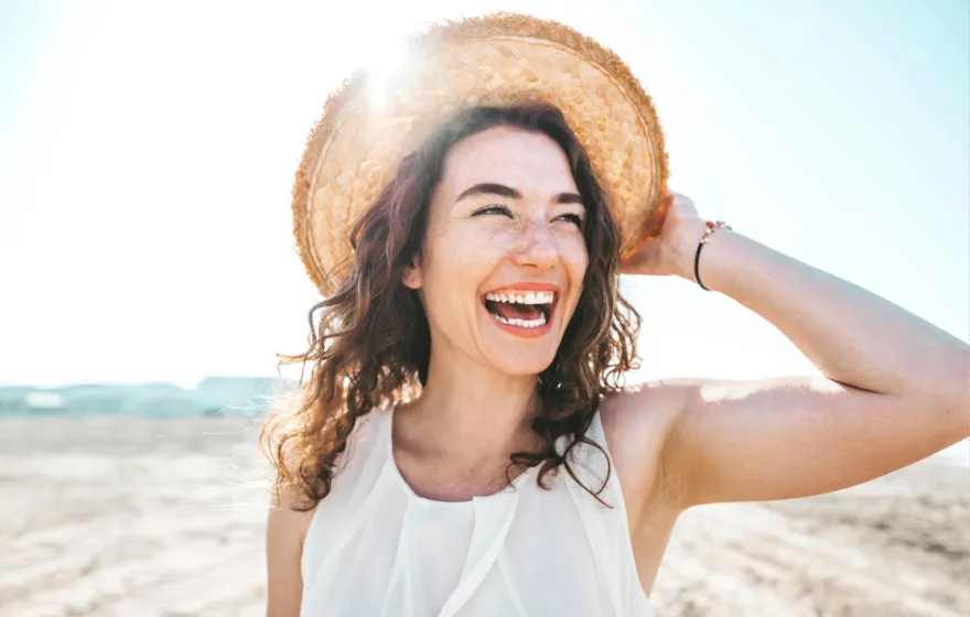 teeth whitening blog titled summer smile - picture has a woman at the beach showing her white teeth