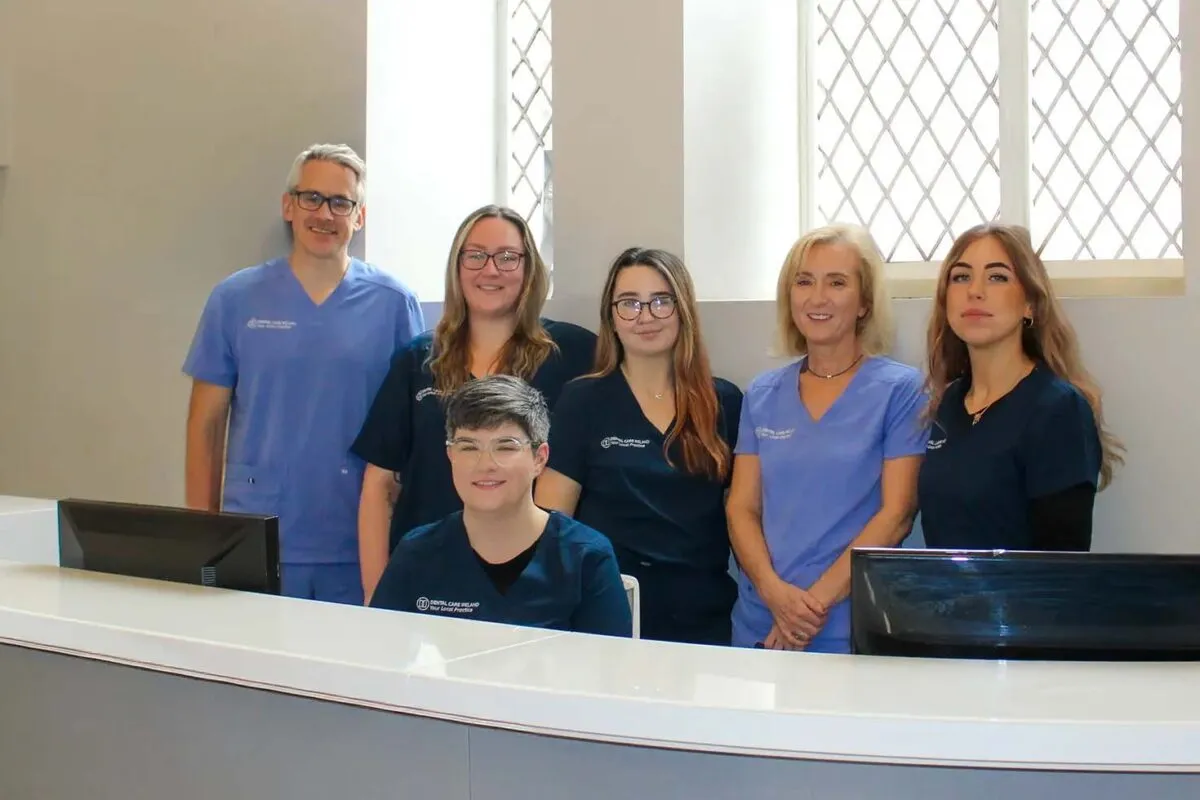 Group of 6 staff at the front reception desk.